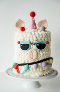 Cake decorated like a llama with colorful accessories 