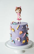Decorative cake with a girl on top and flowers and ice cream